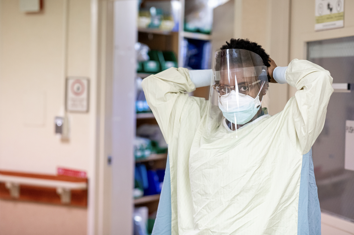 a doctor putting on PPE