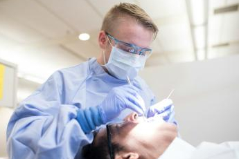 Dental therapist treats patient