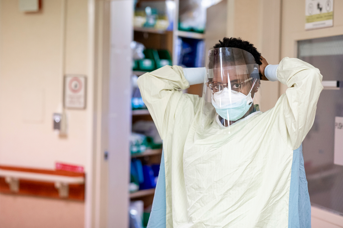 a doctor putting on PPE