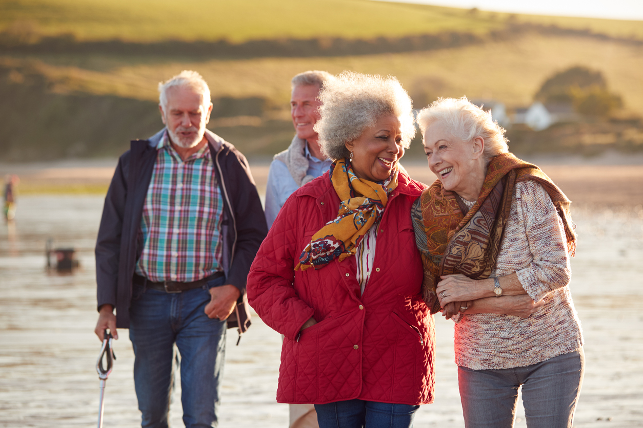 Group Of Smiling Senior Friends Walking Arm In Arm