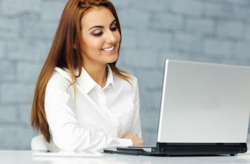 Woman smiling and looking at laptop screen