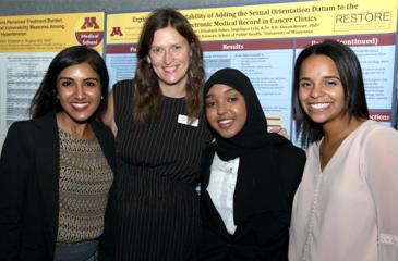 Neelam Chandiramani, PHDR, Megan Larson, CTSI-Ed, Hani Abdi, PReP Scholar, and Jocelyn Ricard, PReP Scholar, stand together in front of a poster at a past Poster Session event