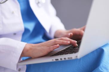 Doctor typing on laptop