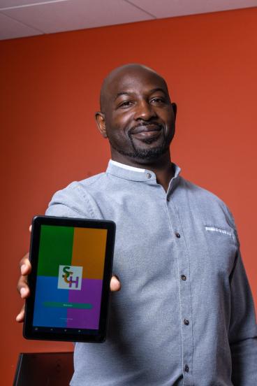 David Haynes holding up a tablet showing the Smart Community Health app