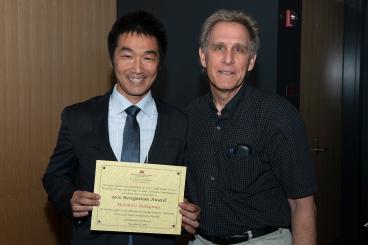 Motohiro Nakajima holding award certificate